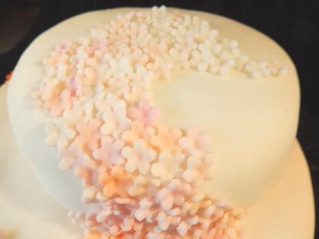 white and pastel peach orange pink cascade of ombre flowers on wedding cake