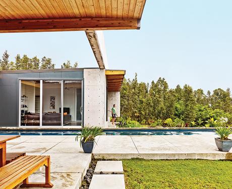 Modern concrete house in Hawaii with bridge going across pool