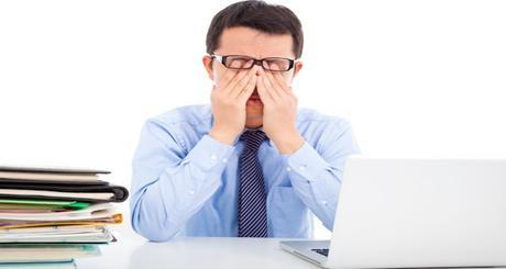 businessman is too fatigued to rubbing his eyes