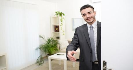 young businessman at doorway giving hand to customer