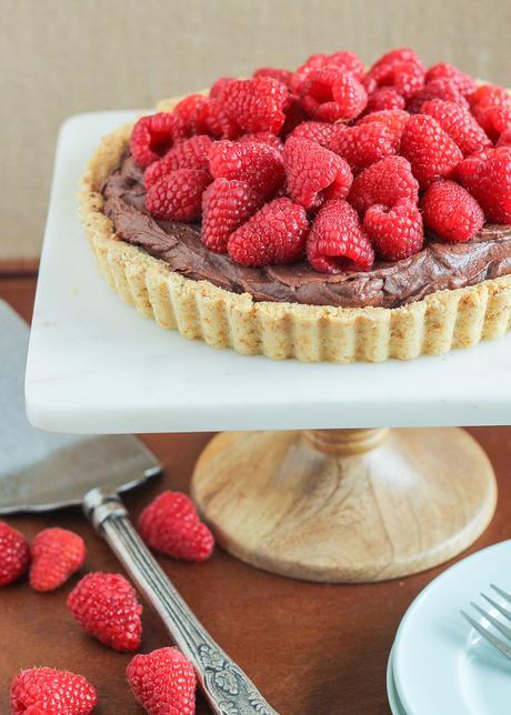 This Whipped Chocolate Ganache Raspberry Tart has an almond flour crust filled with creamy chocolate ganache topped with fresh raspberries! It's naturally gluten free.