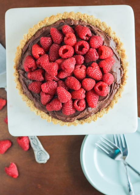 This Whipped Chocolate Ganache Raspberry Tart has an almond flour crust filled with creamy chocolate ganache topped with fresh raspberries! It's naturally gluten free.