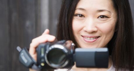 Portrait of a woman holding a home video camera