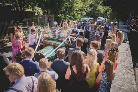 Bride and Groom leaving church in vintage car