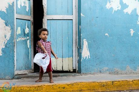 Child playing with a plastic bag outside his home.