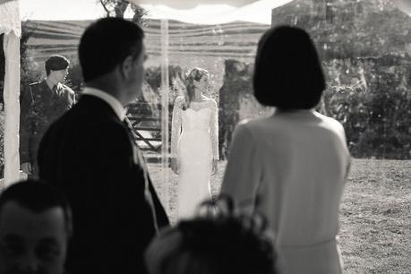 Bride's parents looking through marquee at their daughter