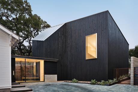 Modern Texan addition and renovation facade with cypress paneling and metal roof