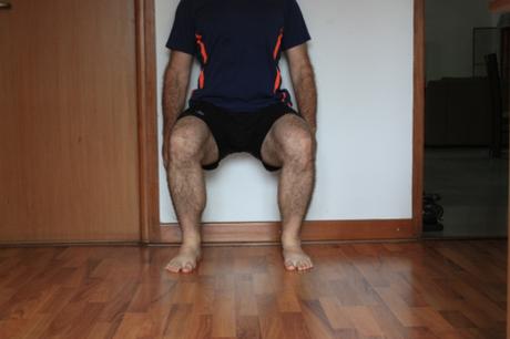 Wall squat: just like sitting on a chair with one's back  to the wall--sans the chair. 