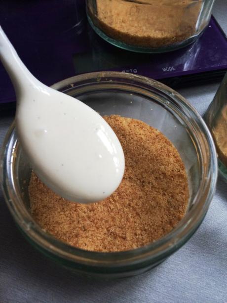 spooning cream cheese mixture into ramekin for cheesecake pots