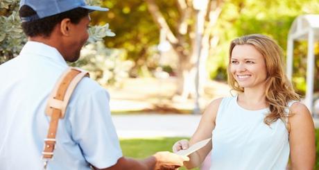 Mailman Delivering Letters To Woman