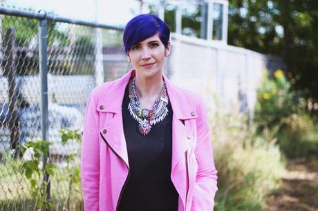 Outfit details: purple pixie haircut, pink moto jacket, layered statement necklaces
