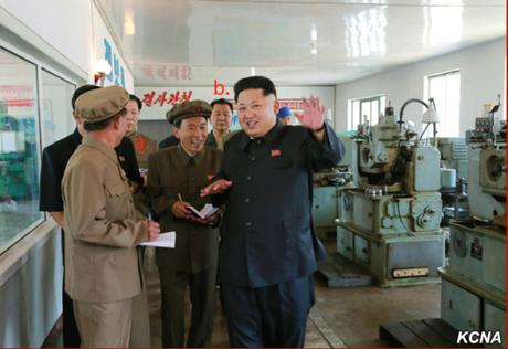Kim Jong Un tours the Sinu'iju Measuring Instruments Factory.  Also in attendance are WPK Secretary Kim Chun Sam (a.) and Second Economy Commission Chairman Jo Chun Ryong (b.) (Photo: KCNA).  