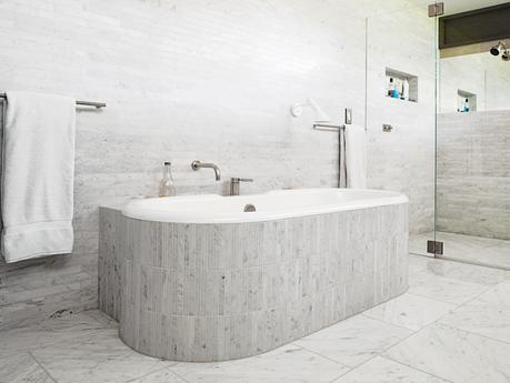 Master bathroom with walls and tub clad in Carrara marble 