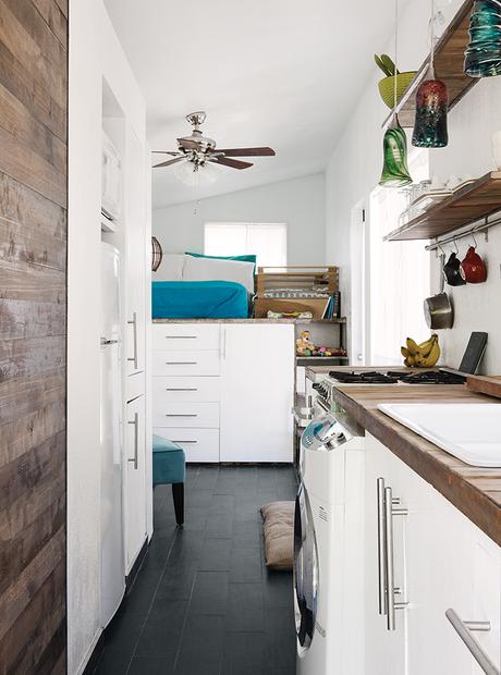 Galley kitchen with a washer-dryer unit and elevated bed