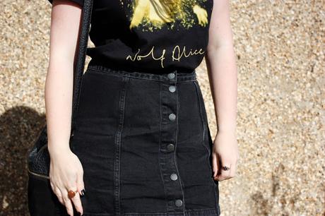Wolf Alice band T tucked into black a line skirt