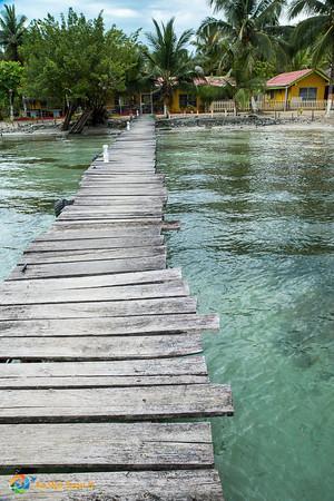 Pier onto Isla Carenero over crystal clear waters.