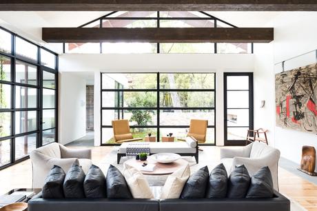 Living room with large windows, sofa, and a skylight