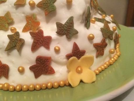 Fondant leaves and flowers with gold soft pearls decoration on autumn showstopper cake
