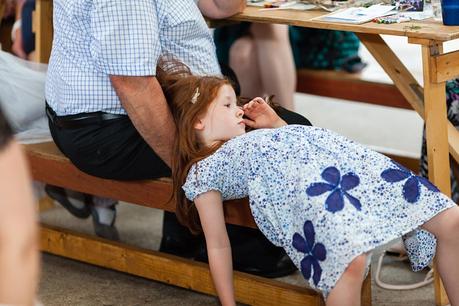 Canidid photographs at barmbyfiled barn wedding little girl on bench