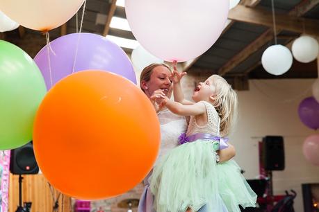 Canidid photographs at barmbyfiled barn wedding flowergirl with balloons