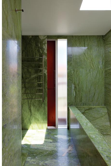 Modern bathroom clad in green Verde Ming marble