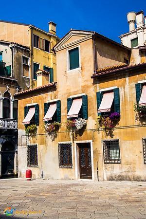 One of Venice's weather-worn buildings, sporting brilliant flower boxes