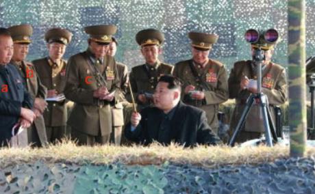 Kim Jong Un is briefed about the anti-air rocket drills. Also in attendance are: Ri Pyong Chol (a); Col. Gen. Yun Tong Hyon (b); and, Gen. Choe Yong Ho (c] (Photo: Rodong Sinmun).
