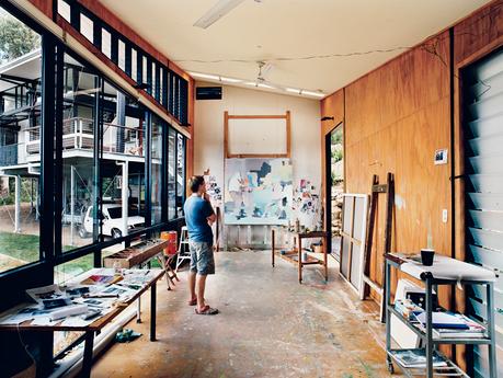 In his detached painting studio, Dunlop considers a work in progress. The building is oriented east-west to avoid direct sunlight, and the long, narrow shape enables the artist to get some distance from his paintings as he works. An oversize front door an