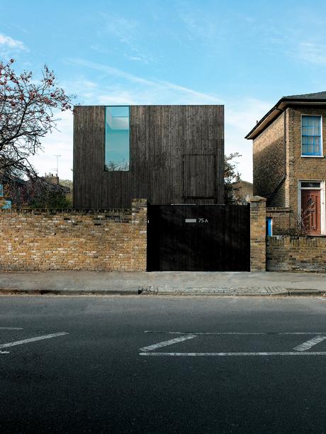 The facade achieves a notable sense of verticality for such a stout structure, with its stained-timber cladding aimed straight up toward the sky. The heavy, horizontal brick-work of the neighboring Georgian houses seems to imply aesthetic controversy, but