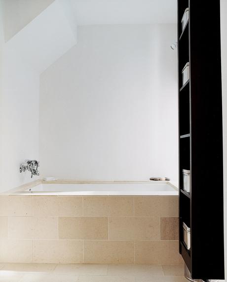 In the master bath, a Zuma tub with Hansgrohe fixtures is covered with limestone tile to soak up the sunshine.