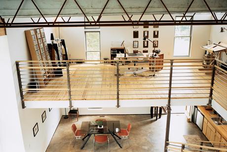 The bedroom overlooks an office, which floats above the kitchen and dining room. The railing and banister were fabricated by a local metal worker a few miles away.