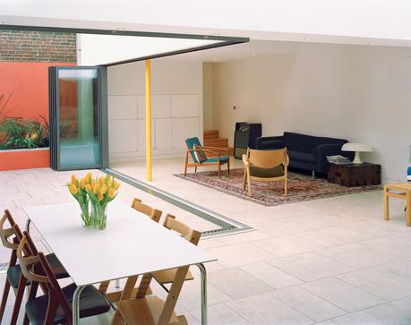 The glass wall separating the main living area and the inner courtyard garden opens like an accordion to create a barrier-free transition. Built-in planters along the walls of the courtyard add greenery without eating into the valuable surface 
area of th