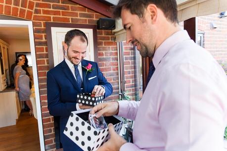 Groom and best man open gifts