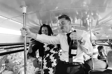Revelry and shenanigans with wedding guests on double decker bus at fun wedding