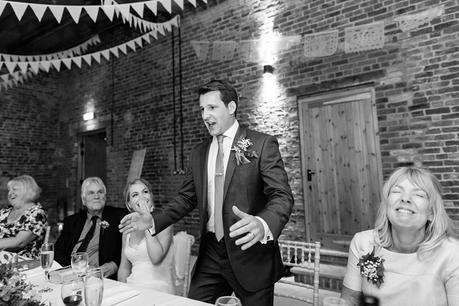 Groom making a funny expression during speech at wedding