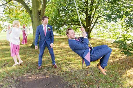 Groom pushing best man on swing 