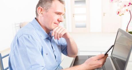 Hearing impaired man working with laptop and mobile phone at home or office