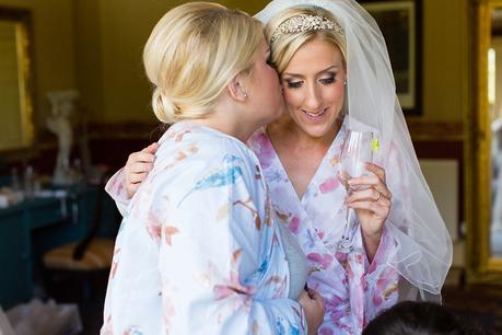 Bridesmaid kisses bride at crow hill wedding