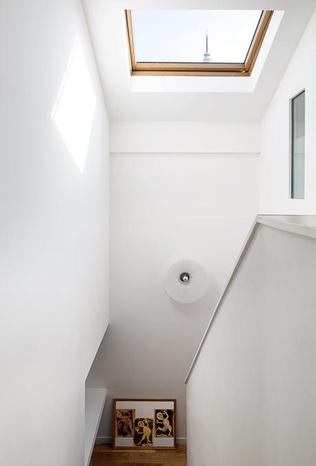 modern prefab home in Paris suburb with Velux skylight and light fixture above staircase