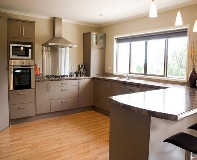 A large modern kitchen with stainless steel accessories and wooden floor