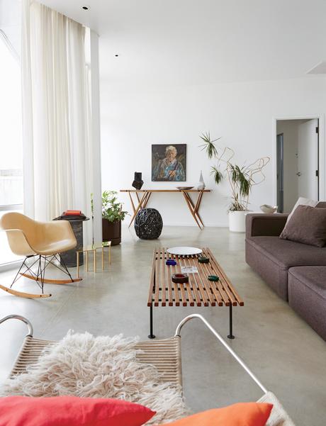Mondern prefab Chicago live/work space by UrbanLab with Baldwin Kingrey coffee table, Eames rocker, Jonathan Muecke brass low table in the living area