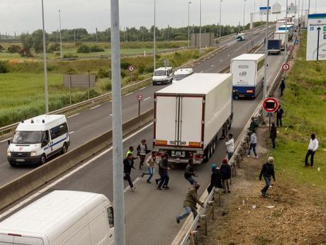 Migrants attempt to get on truck in Calais (AFP/Getty Images)