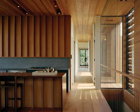 Open kitchen made of mahogany with a volcanic stone backsplash