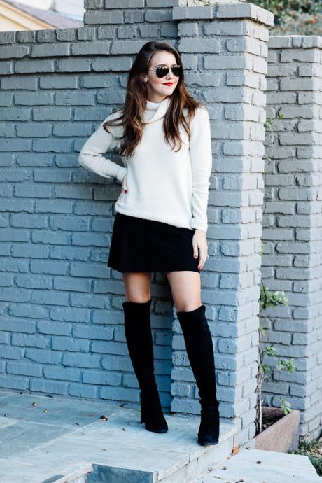 Amy Havins wears a cozy sweater paired with a black skirt and over the knee boots.