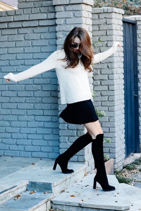 Amy Havins wears a cozy sweater paired with a black skirt and over the knee boots.