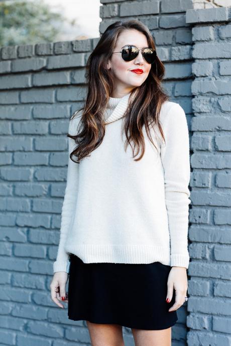 Amy Havins wears a cozy sweater paired with a black skirt and over the knee boots.