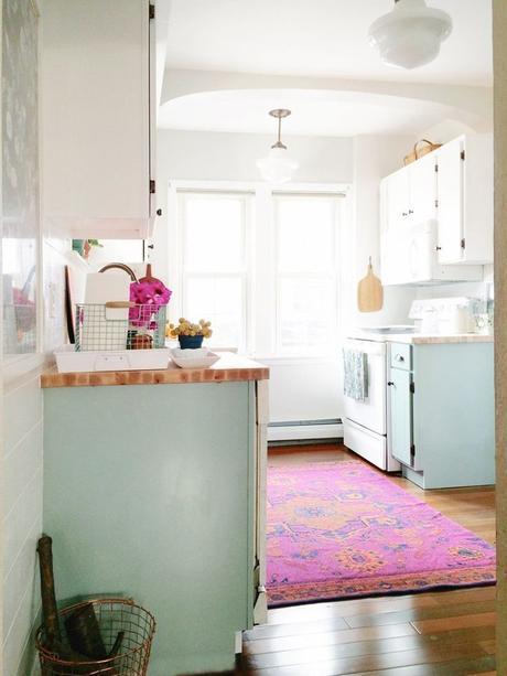 Pink Persian rug and light blue cabinets in kitchen: 
