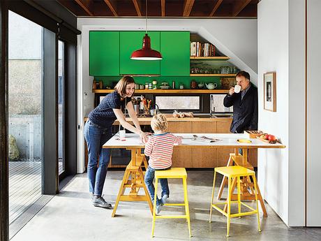 Bright kitchen with green cabinets and an Achille Castiglioni table