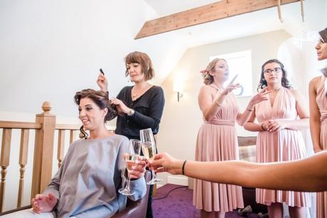 Bride sharing champagne with bridesmaid