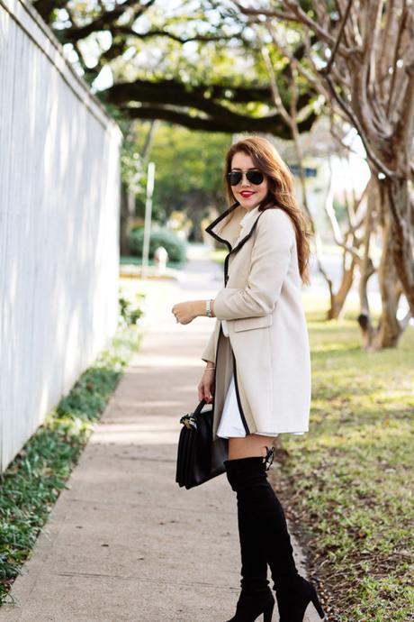 Amy Havins wears a camel coat paired with black over the knee boots.